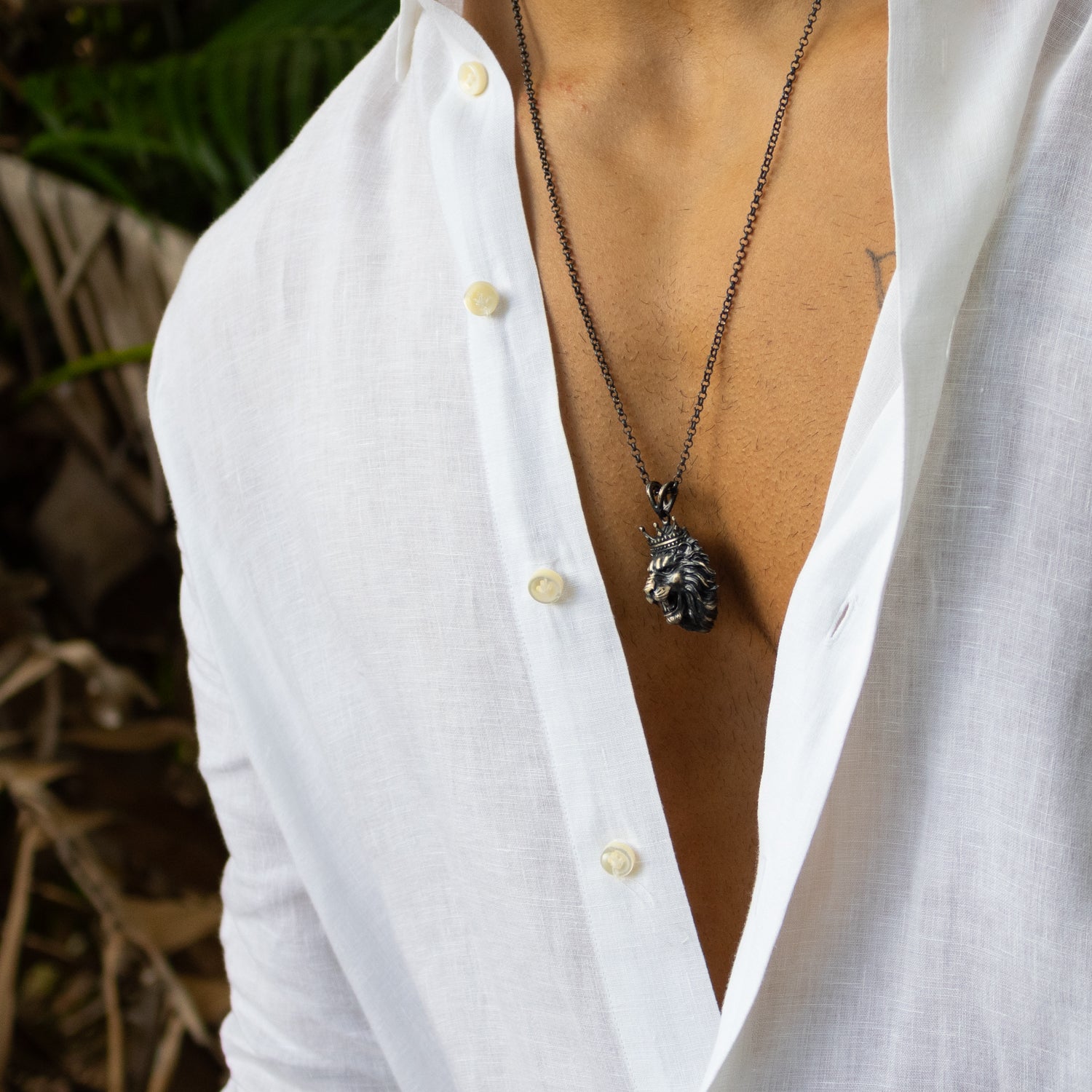 Sterling silver necklace with crowned lion head pendant, rhodium finish, black and silver accents, regal design, bold masculine style.