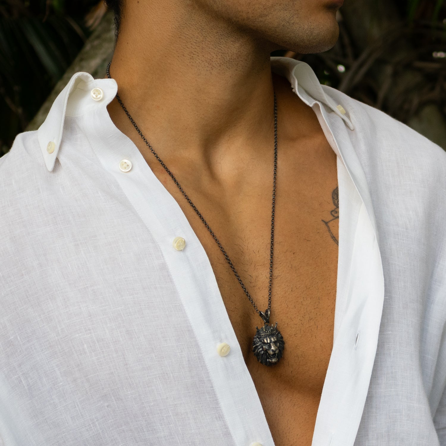 Sterling silver necklace with crowned lion head pendant, rhodium finish, black and silver details, regal design, bold masculine style.