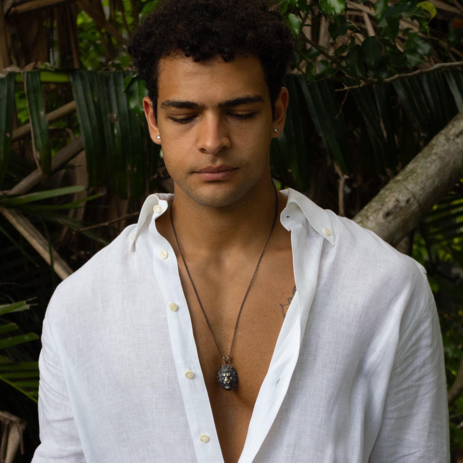 Sterling silver necklace with crowned lion head pendant, rhodium finish, black and silver accents, regal and bold masculine style.