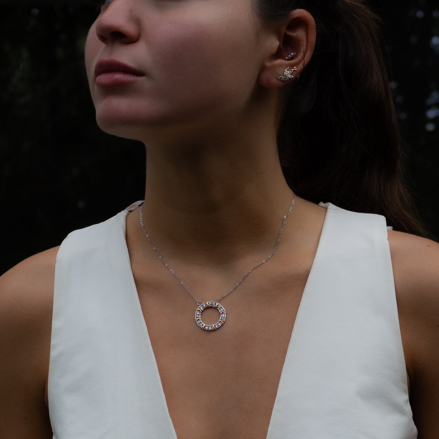 Elegant silver chain necklace featuring a round pendant adorned with sparkling Cz diamonds and gold X designs.
