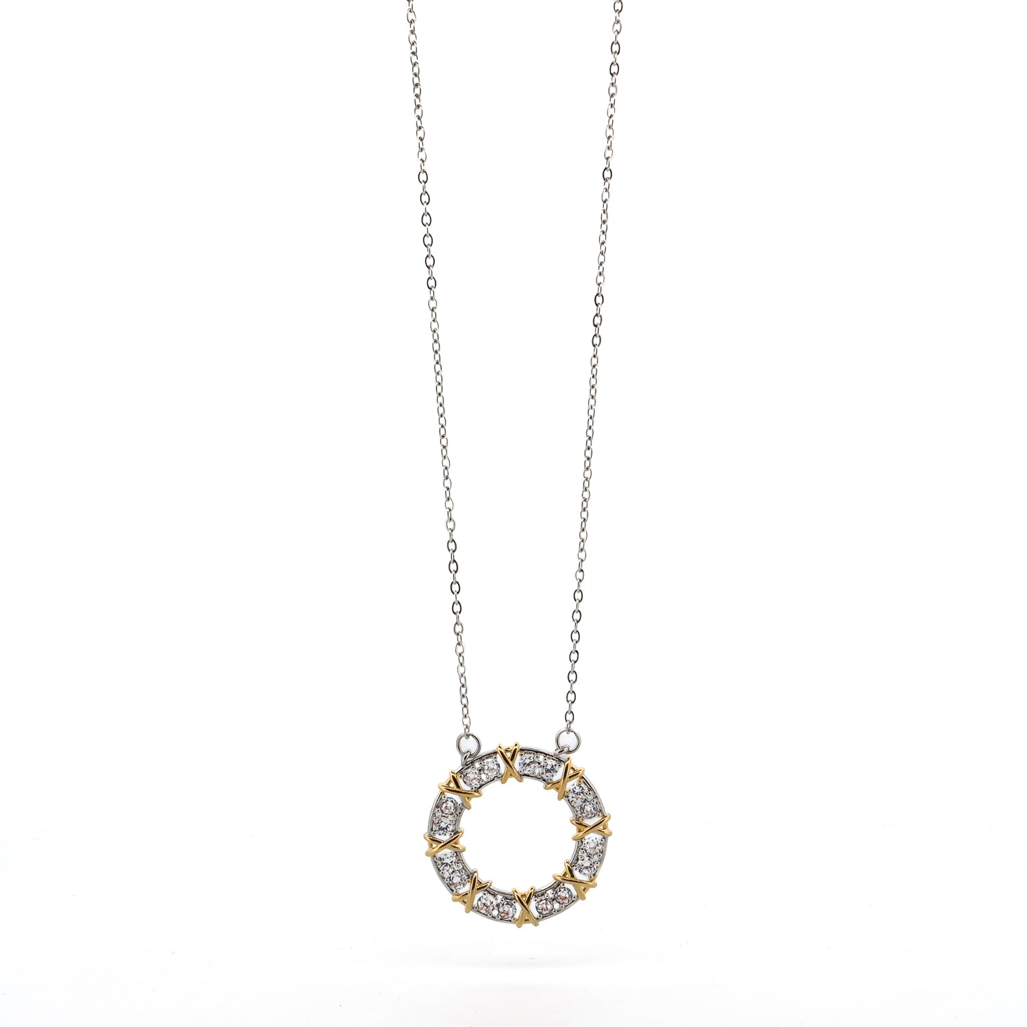 Close-up of a silver necklace with a diamond-studded round pendant and intricate gold X accents.
