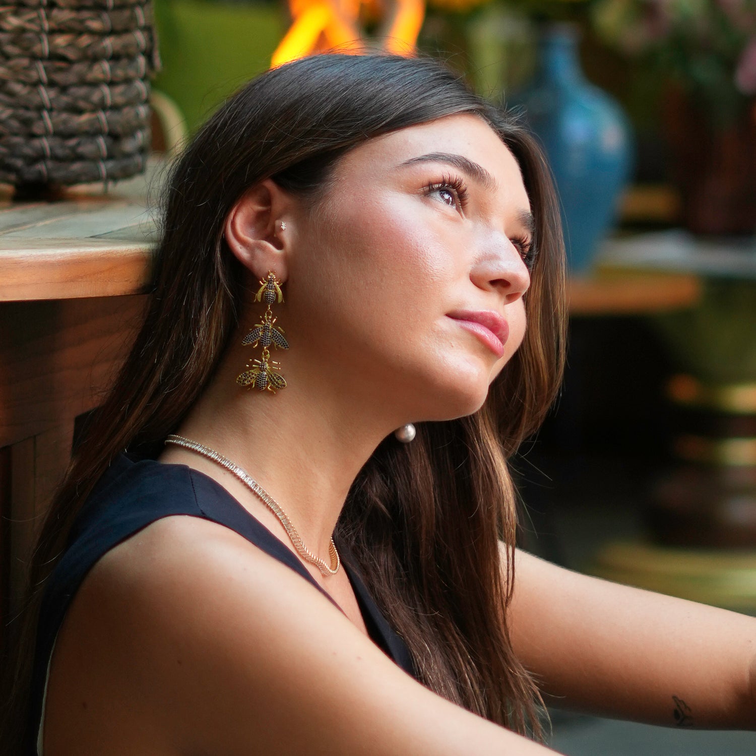 Luxurious gold dangle earrings featuring three sapphire-encrusted queen bees, designed to make a bold and empowering statement.
