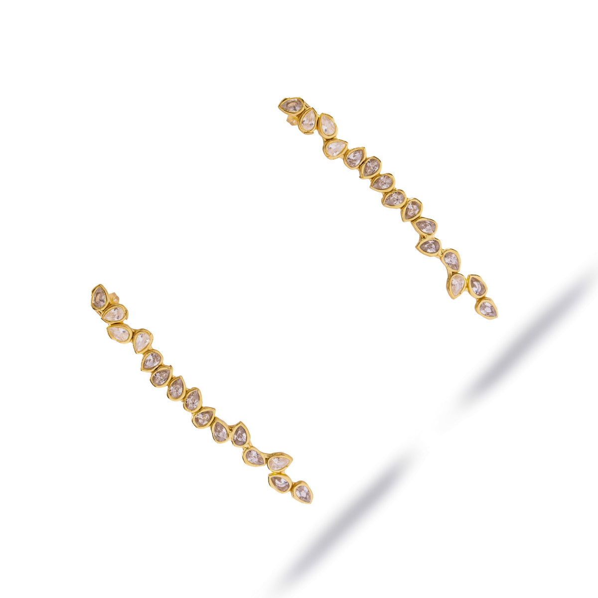 Gold vine drop earrings with alternating pear cut stones shown diagonally on a white background