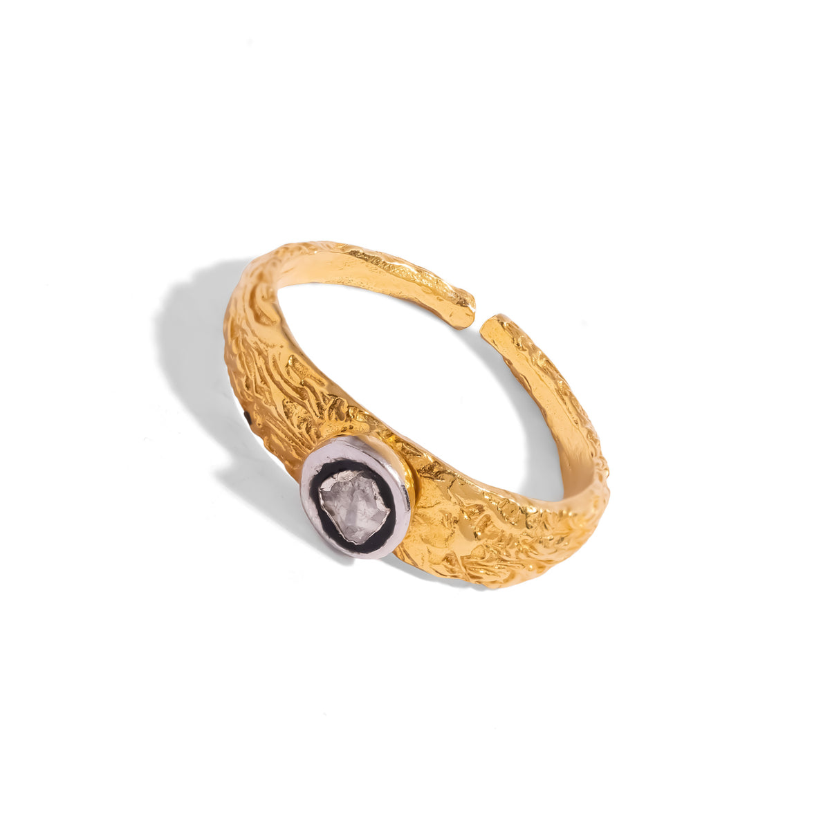 Three quarter studio view of the Antique Ember ring, the rose cut diamond in its silver bezel against richly textured 24K gold plating