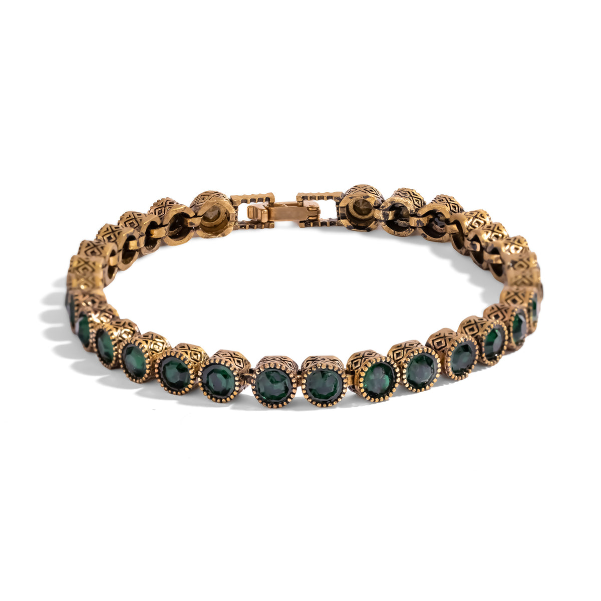 Front view of the emerald antique gold tennis bracelet laid flat, clasp closed