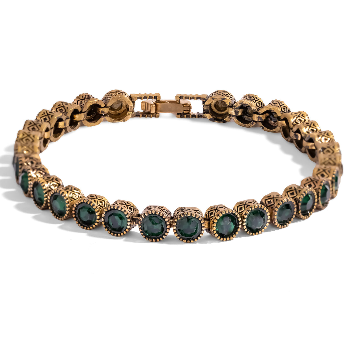 Emerald Antique Gold Tennis Mystic Bracelet, a continuous line of faceted emerald green stones in antiqued gold bezels with a fold over clasp