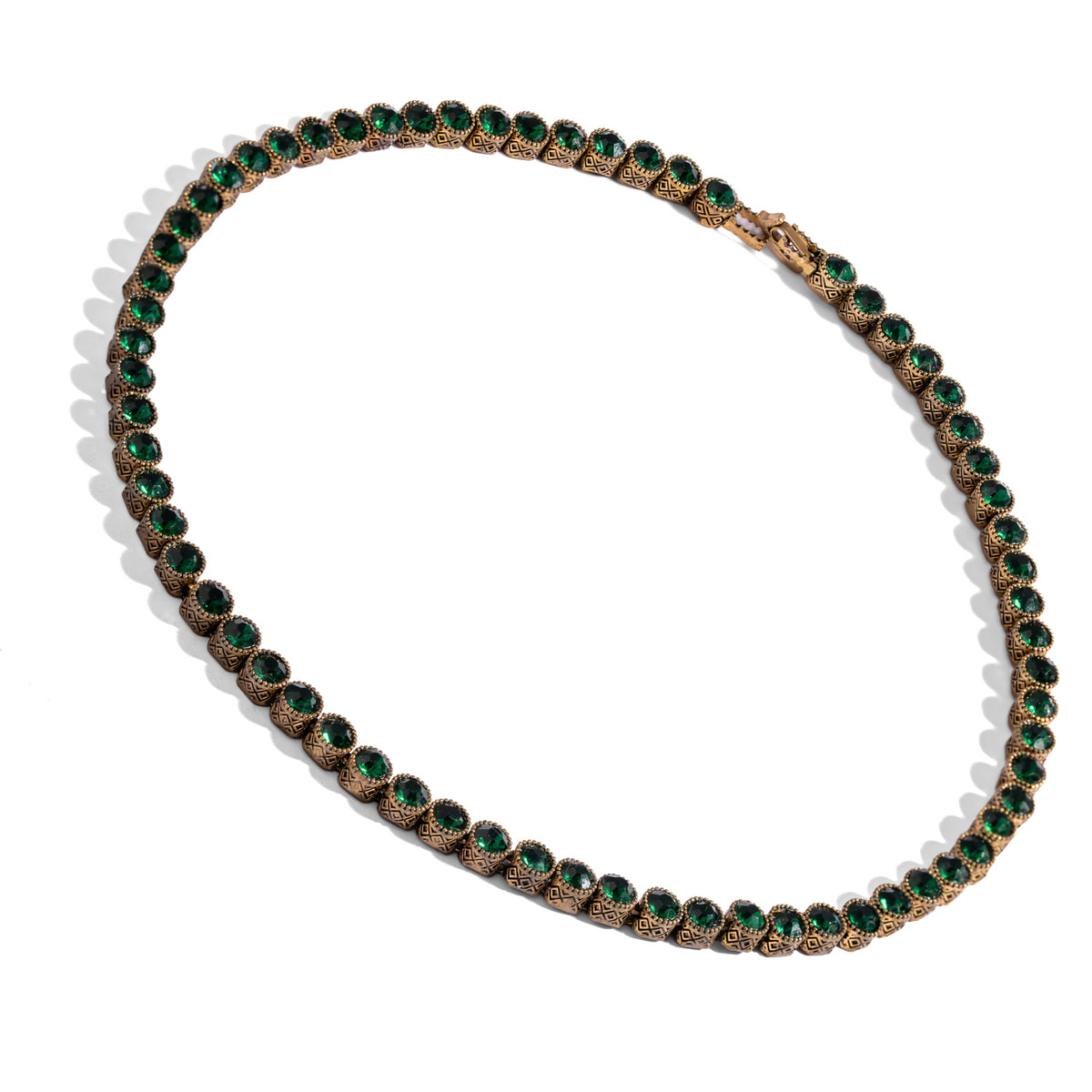 Angled studio view of the emerald tennis necklace showing the concealed box clasp and the diamond motif bezels