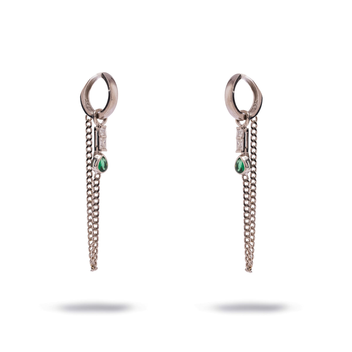 Sterling silver huggie earrings with a draped double curb chain, a baguette stone and a pear shaped emerald drop