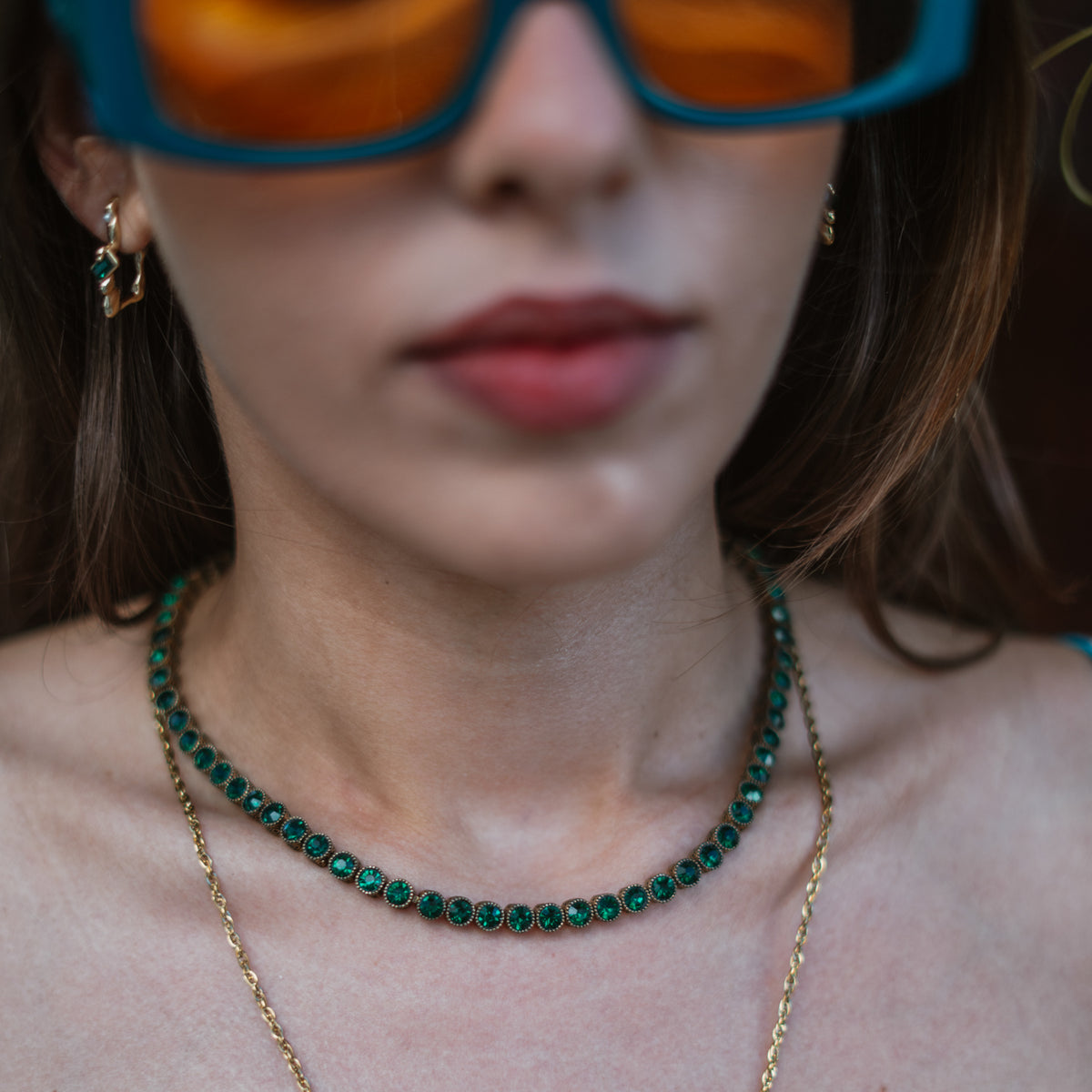 The Emerald Flow gold earring worn with a green stone tennis necklace and a fine gold chain