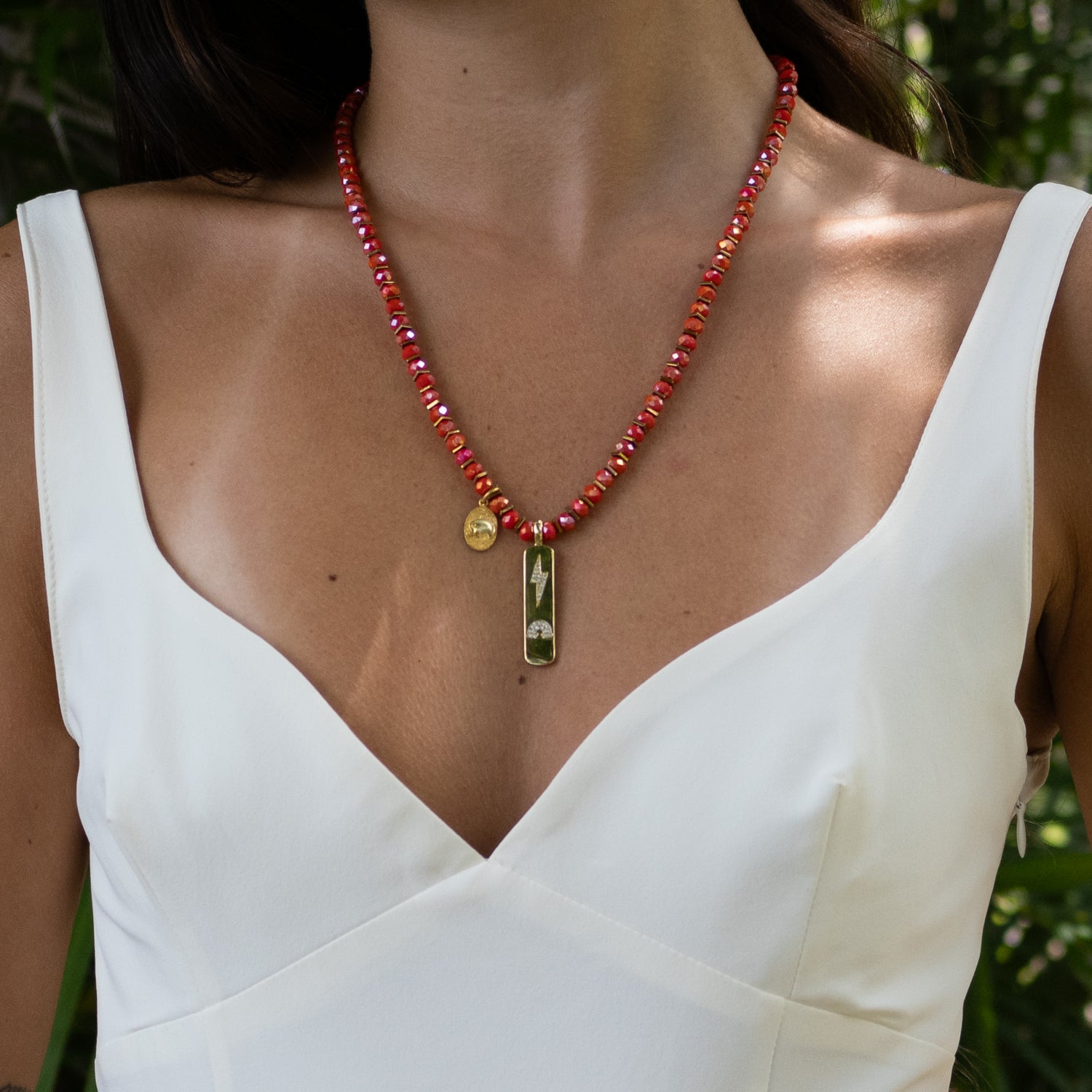 Handmade beaded necklace featuring elephant charm and faceted orange crystals.

