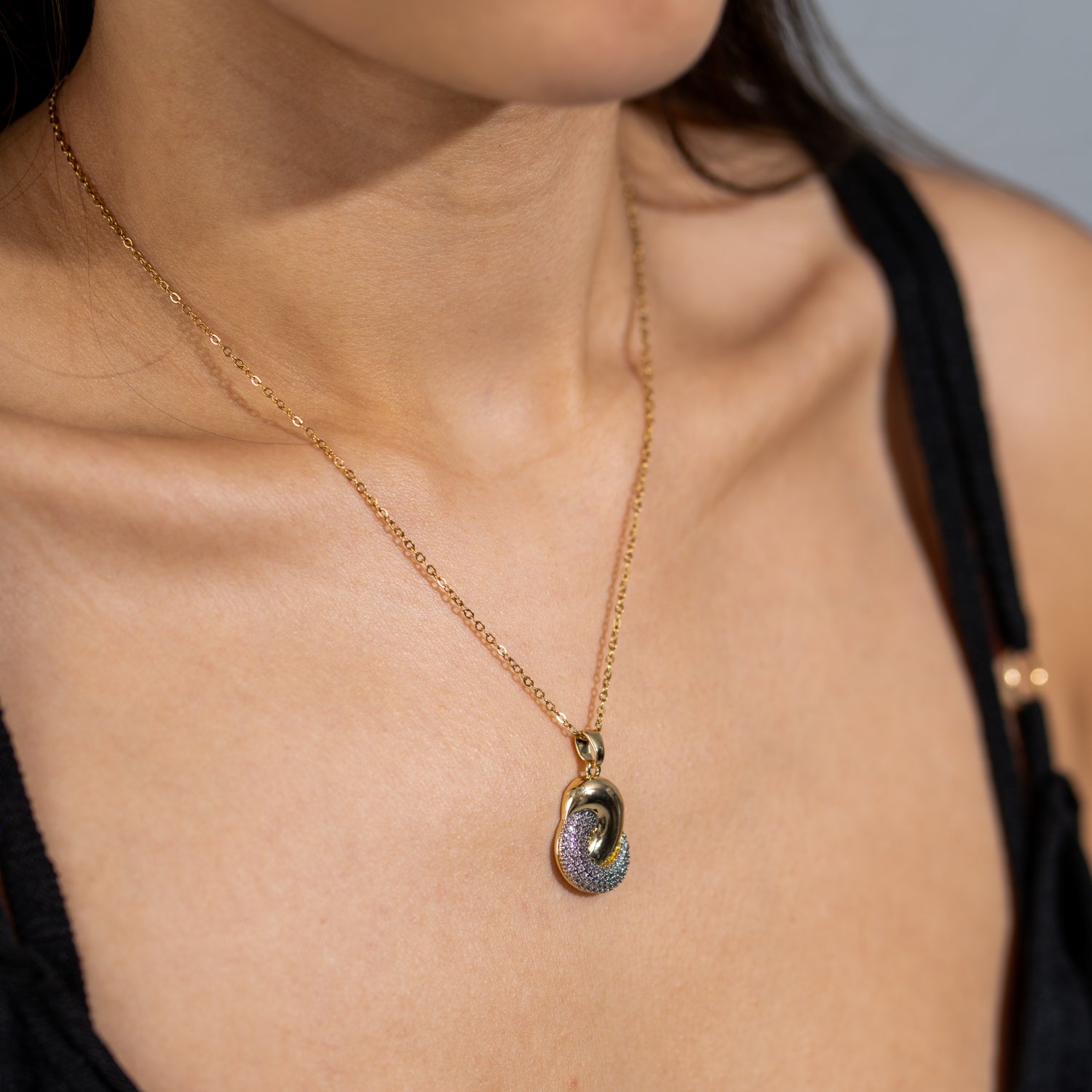 Gold twist pendant gold necklace with half polished metal and half pavé CZ diamonds on a delicate gold chain.
