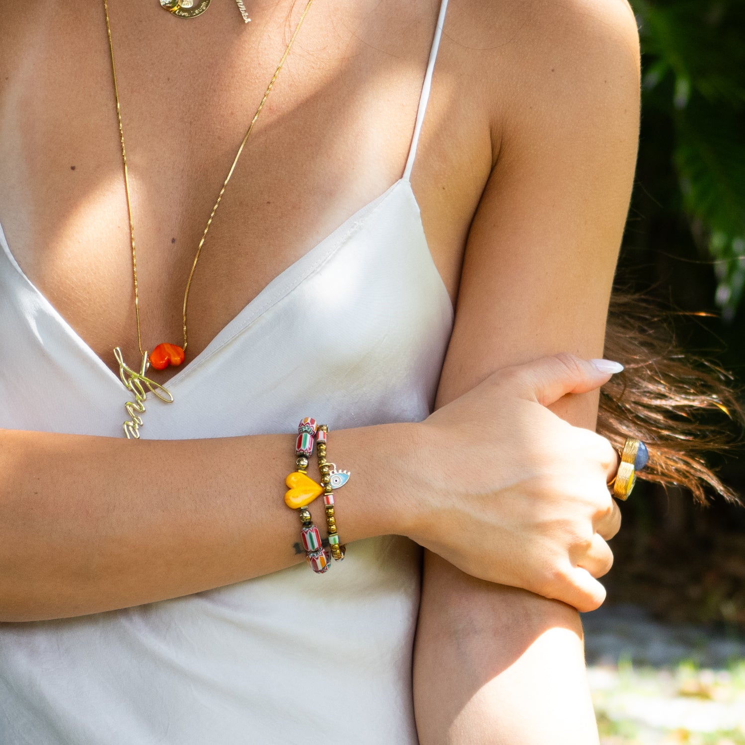 Handmade bracelet duo featuring colorful ceramic beads and blue evil eye charm.

