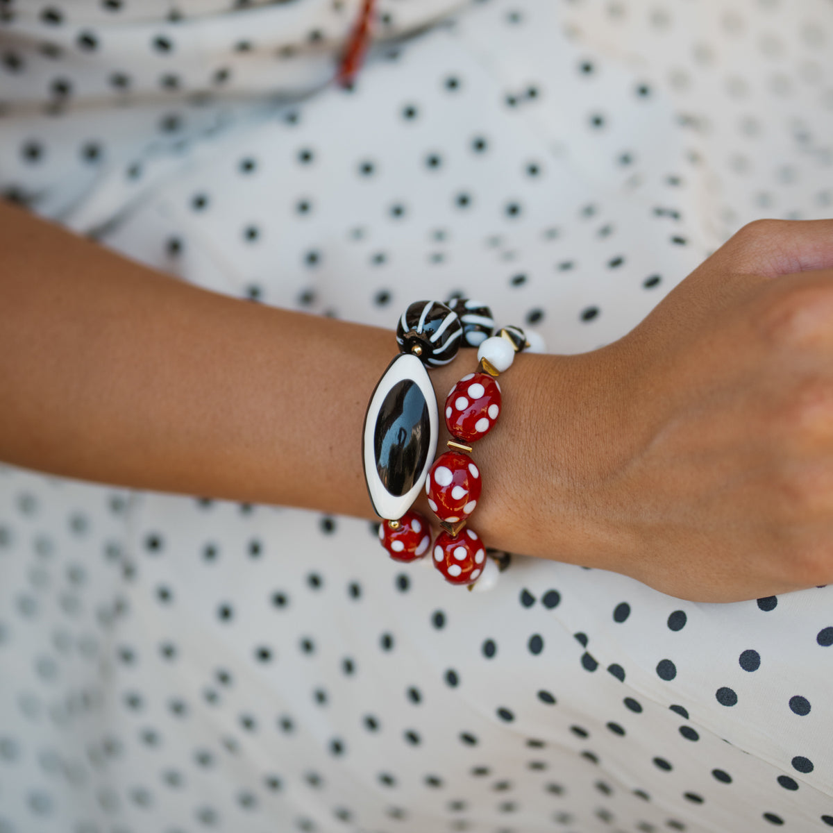 Eye See You Agate Beaded Bracelet Set worn on the wrist against a black and white polka dot fabric