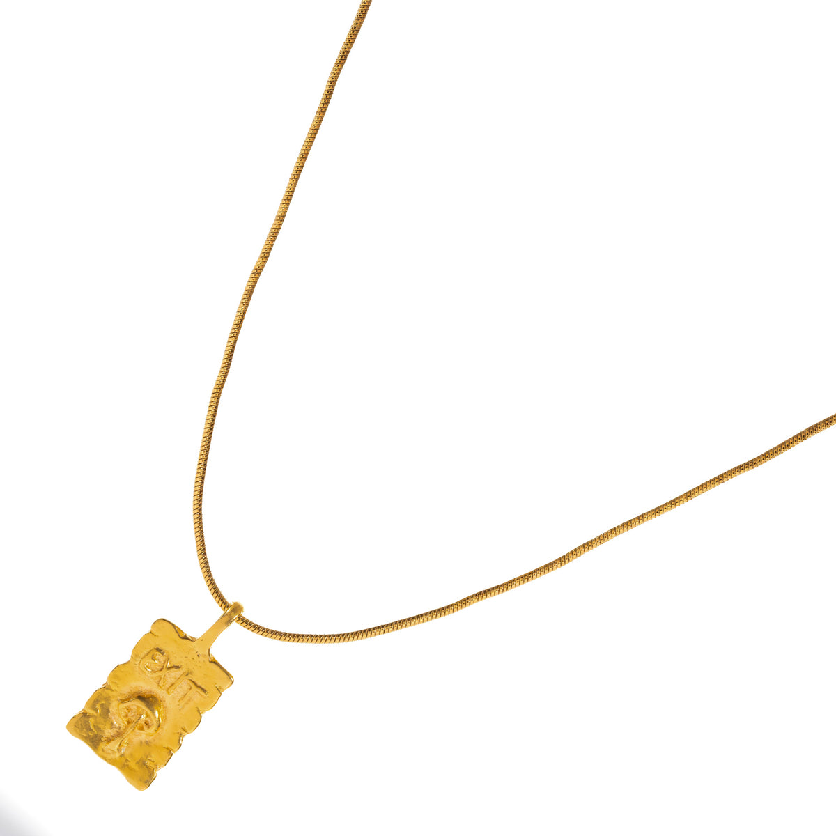 Exit engraved gold pendant at an angle, showing the raw texture and uneven edges