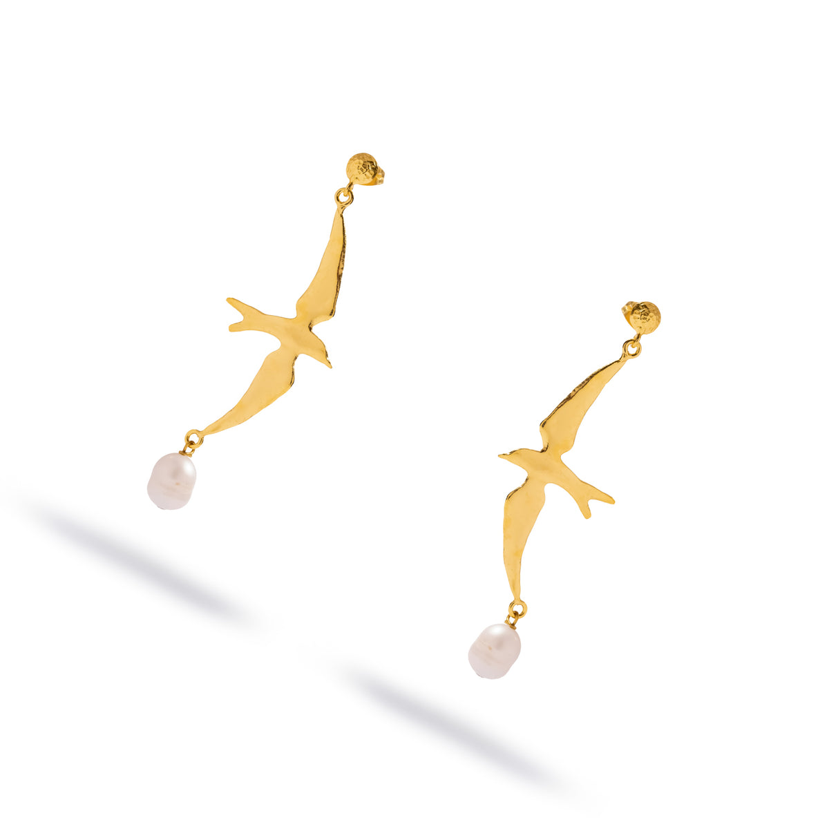 Free Spirit Sparrow Pearl Gold Drop Earrings shown at an angle, swept wing sparrow silhouette with a white pearl drop