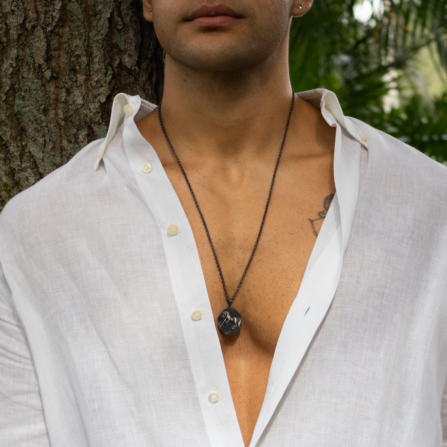 Sterling silver necklace with octagonal horse medallion pendant, rhodium finish, bold masculine style symbolizing freedom and strength.
