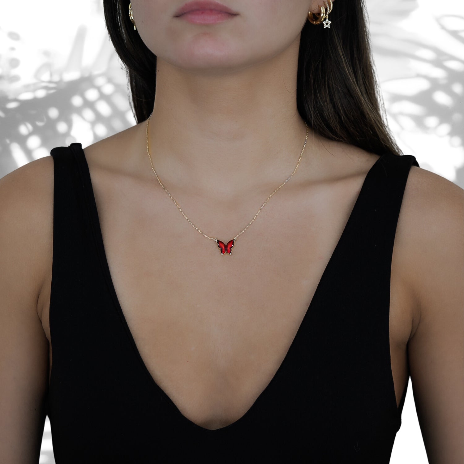 A close-up of a model wearing the Gold Joy Red Enamel Butterfly Necklace, showcasing its intricate details.