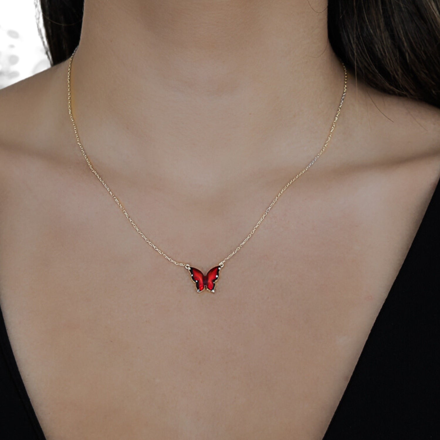 A model wearing the Gold Joy Red Enamel Butterfly Necklace, radiating spirituality and joy.
