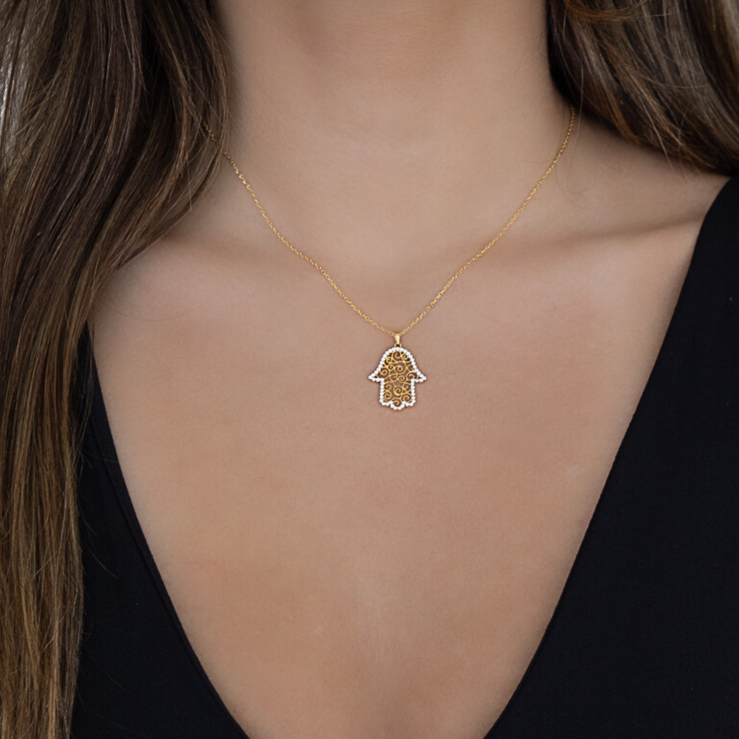 Model wearing the Gold Spiral Hamsa Necklace, showcasing the elegance and meaning behind the Hamsa pendant and the sparkle of the CZ diamonds.