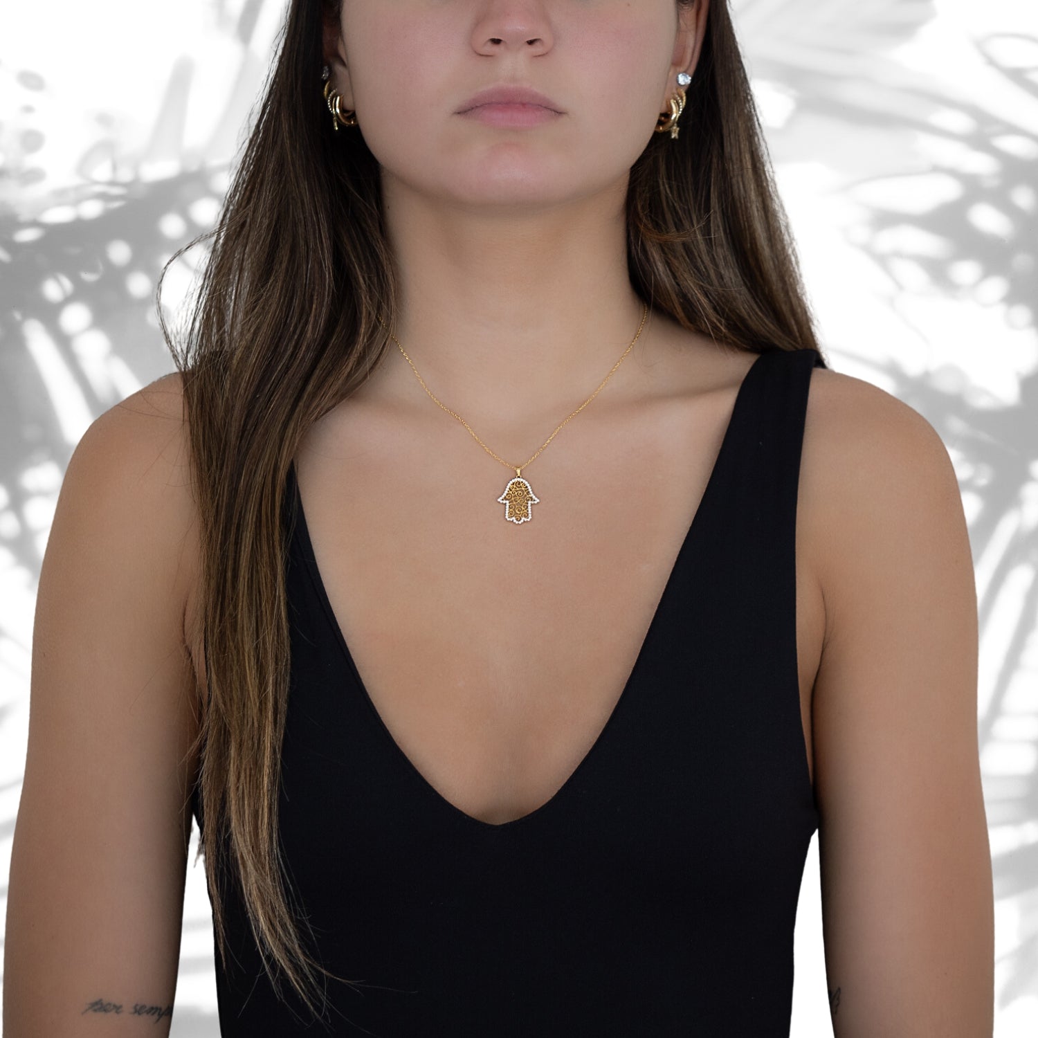 Stylish shot of a model wearing the Gold Spiral Hamsa Necklace, exuding confidence and showcasing the symbolic beauty of the Hamsa pendant.