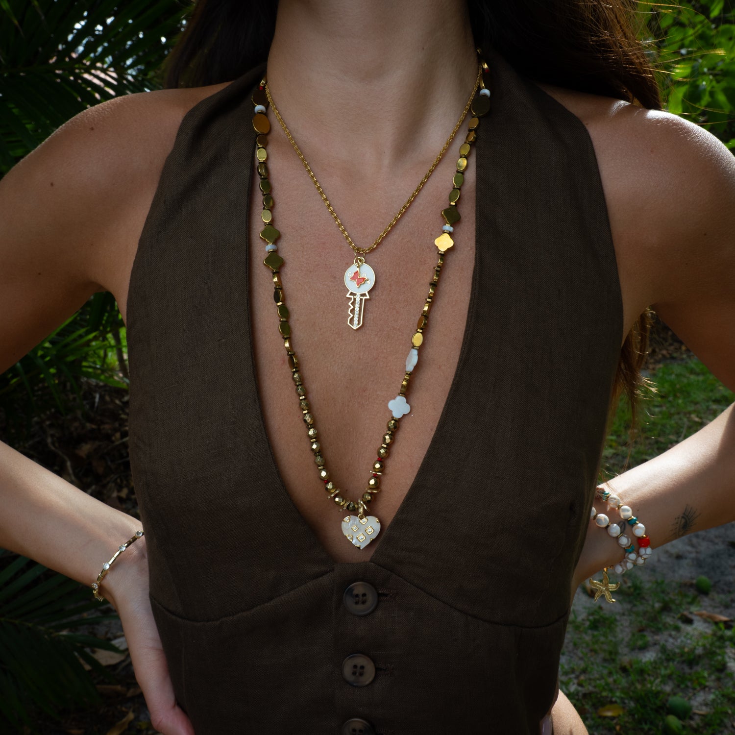 Model wearing Good Luck key butterfly pendant necklace layered, dainty gold styling