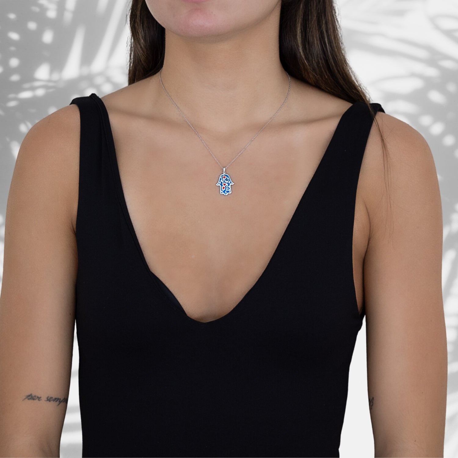 A model wearing the Good Vibes Enamel Hamsa Necklace Silver, radiating positive energy and style.