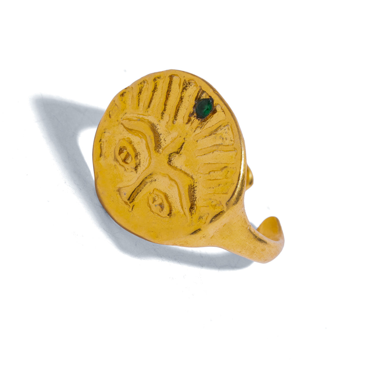 Guardian Emerald Eye Adjustable Gold Ring tilted on white, wide carved eyes and the emerald set among the rays