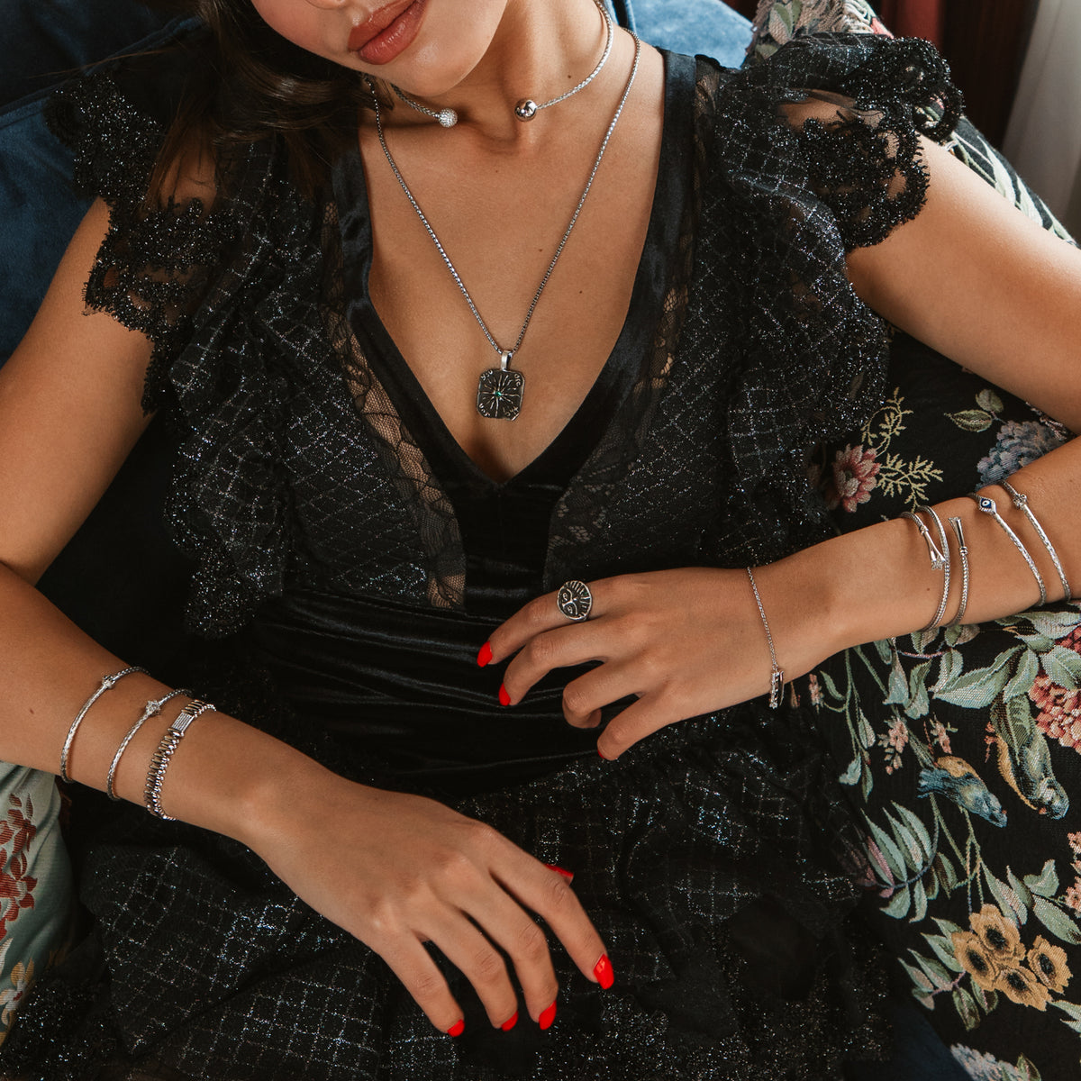 Model in black lace with silver bangles on both wrists, wearing the Guardian Emerald Eye sterling silver ring