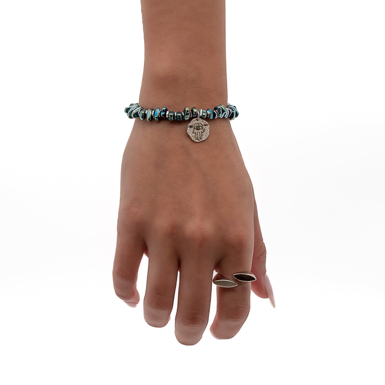 Another hand model wearing the Guardian Hamsa Bracelet, demonstrating its versatility and how it can be stacked with other bracelets or worn alone. 