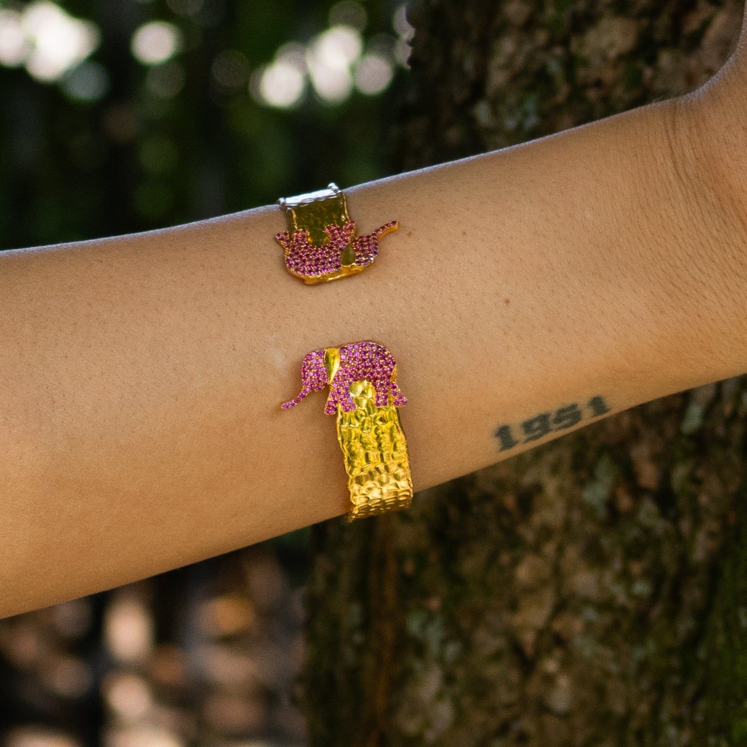 18K gold plated bronze cuff bracelet featuring two ruby-red crystal elephants, adjustable design, bold and elegant fashion jewelry.