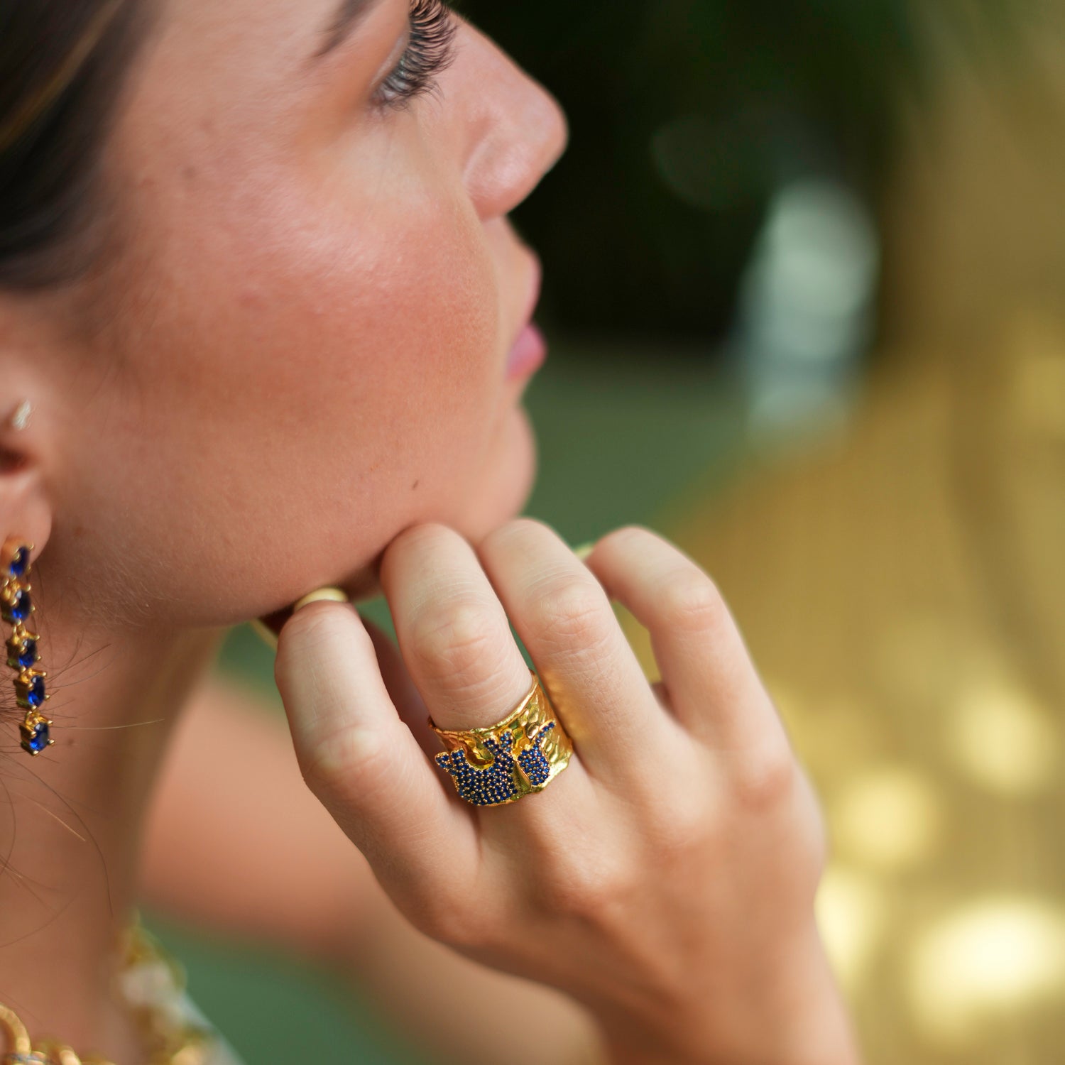 Statement ring featuring a lucky elephant embellished with deep blue sapphire stones, set in 24k gold-plated brass with an adjustable band.
