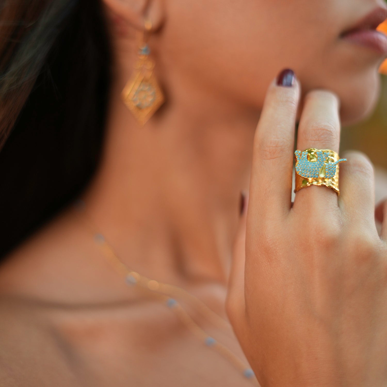 Elegant chunky ring with a turquoise crystal elephant design, made from 24k gold-plated brass, adjustable for a perfect fit.
