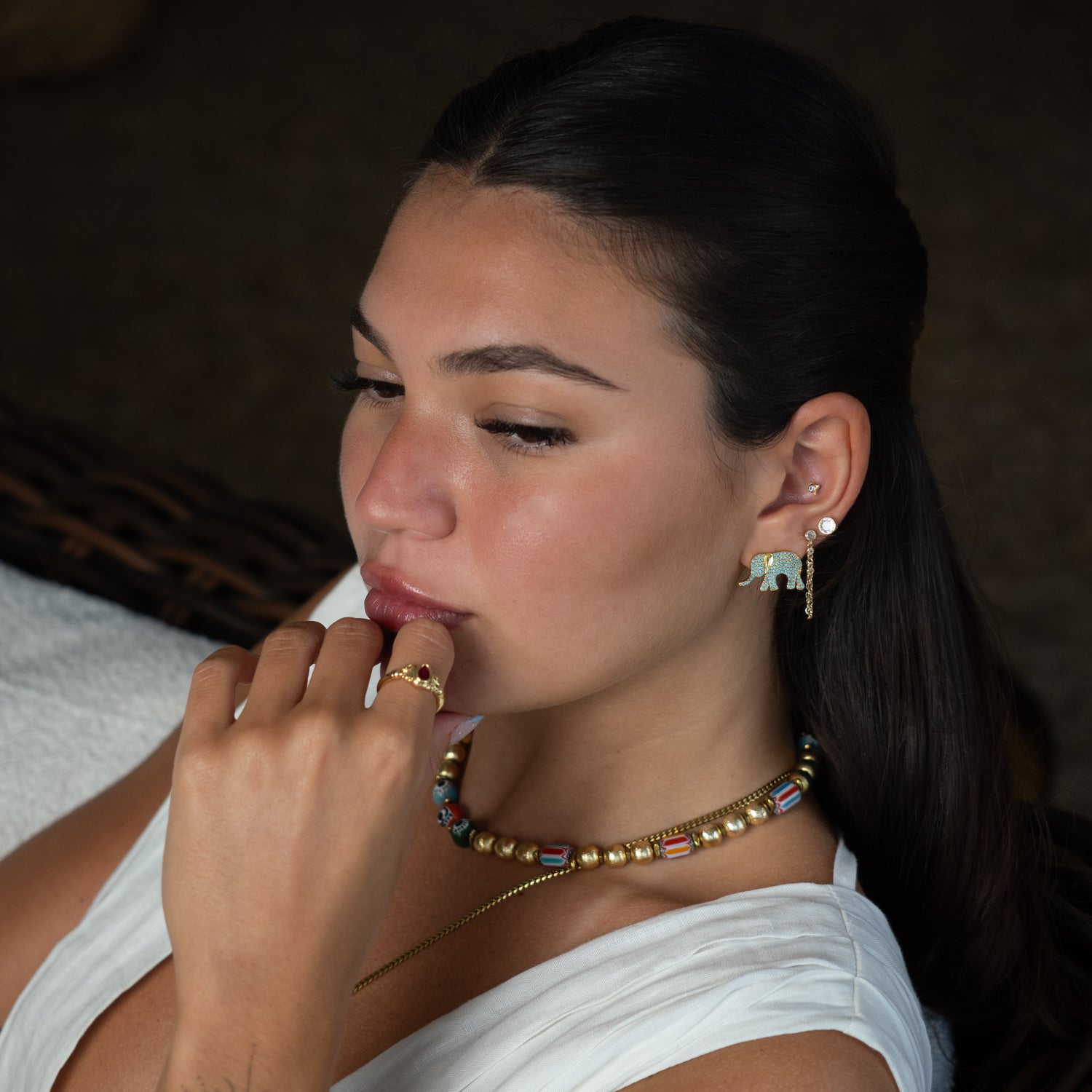 Model wearing Guardian Turquoise Elephant gold stud earrings with beaded necklace