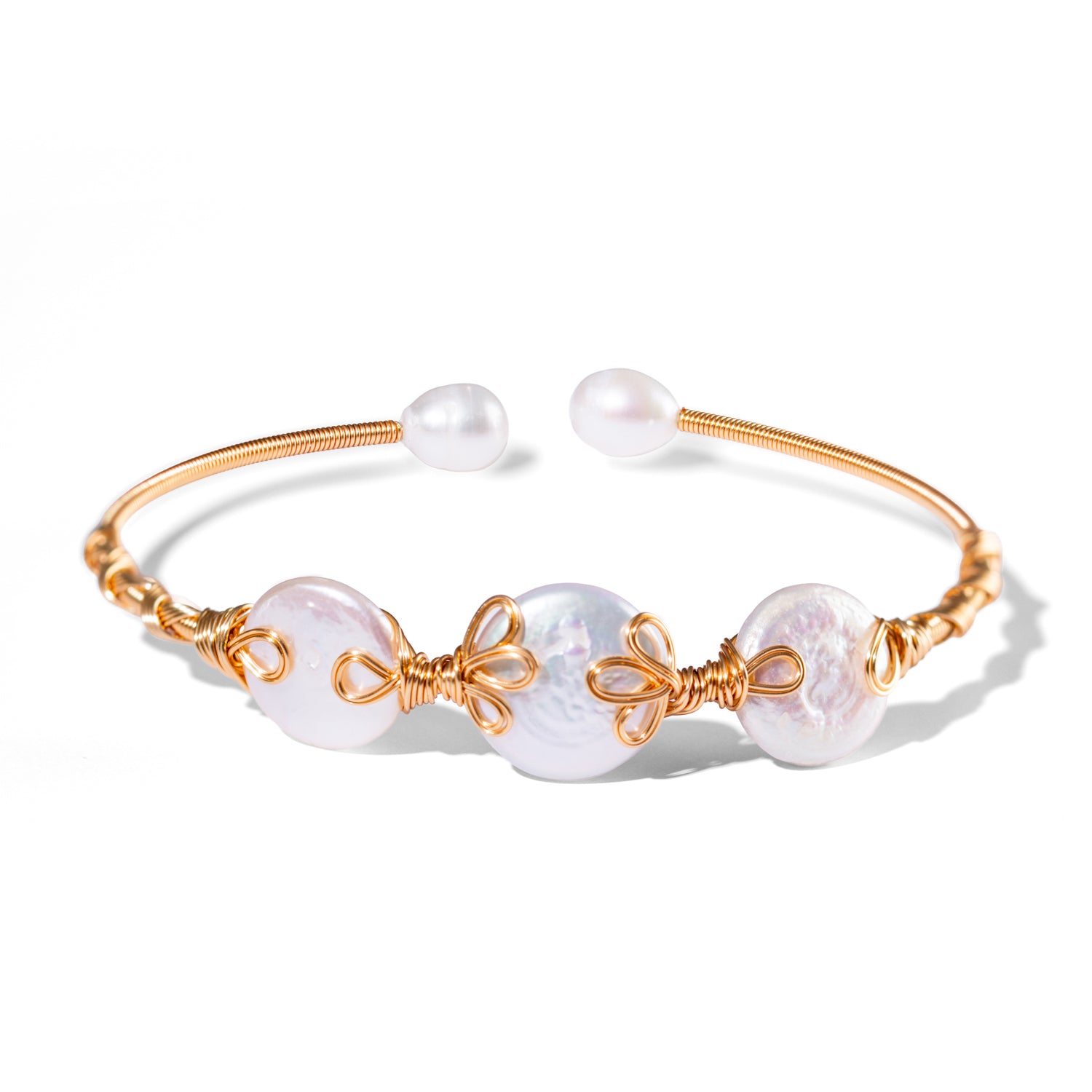 Handcrafted open cuff bracelet with organic baroque pearls wrapped in 18K gold-plated wire on an adjustable gold band.
