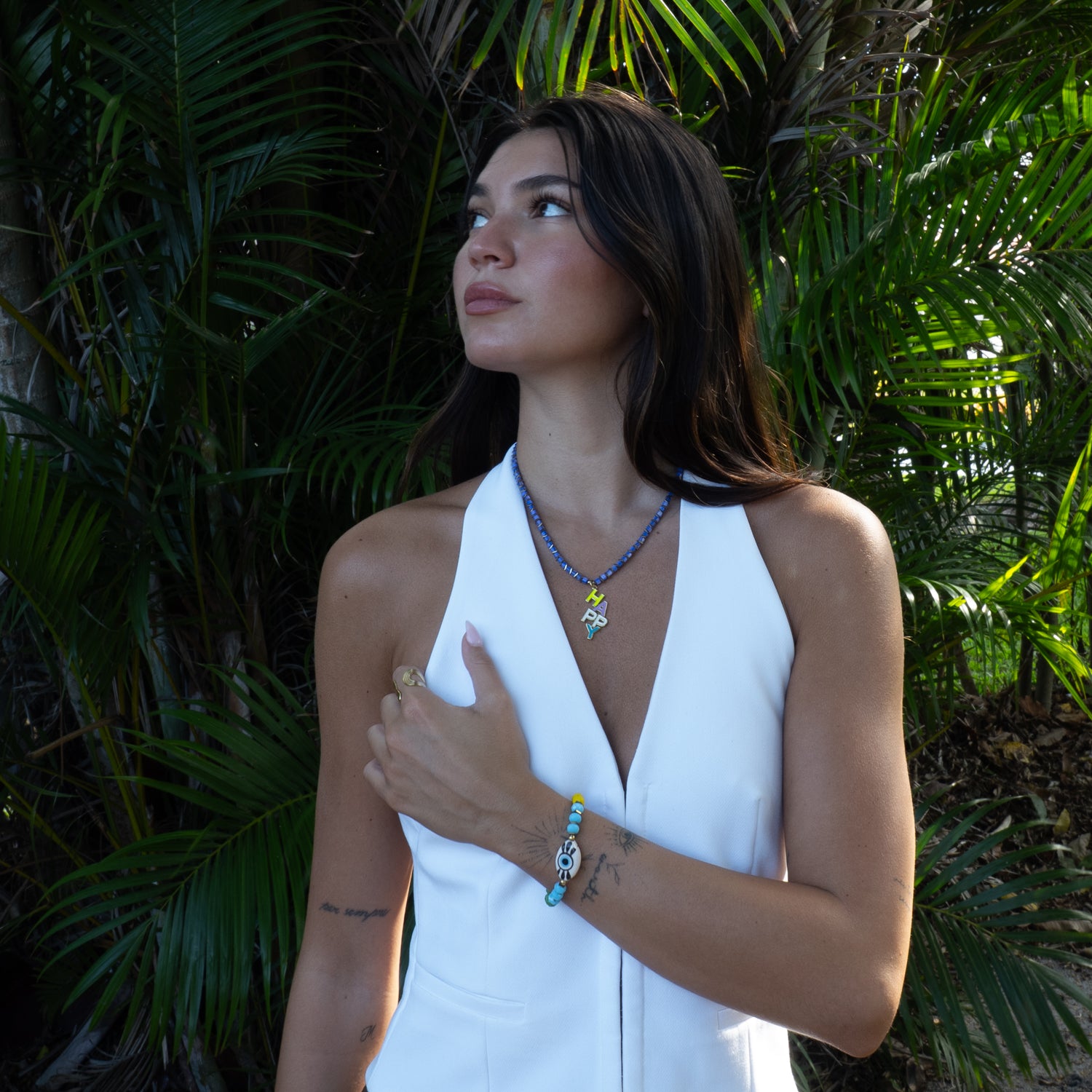 Model wearing Ebru Jewelry colorful HAPPY pearl pendant necklace outdoors