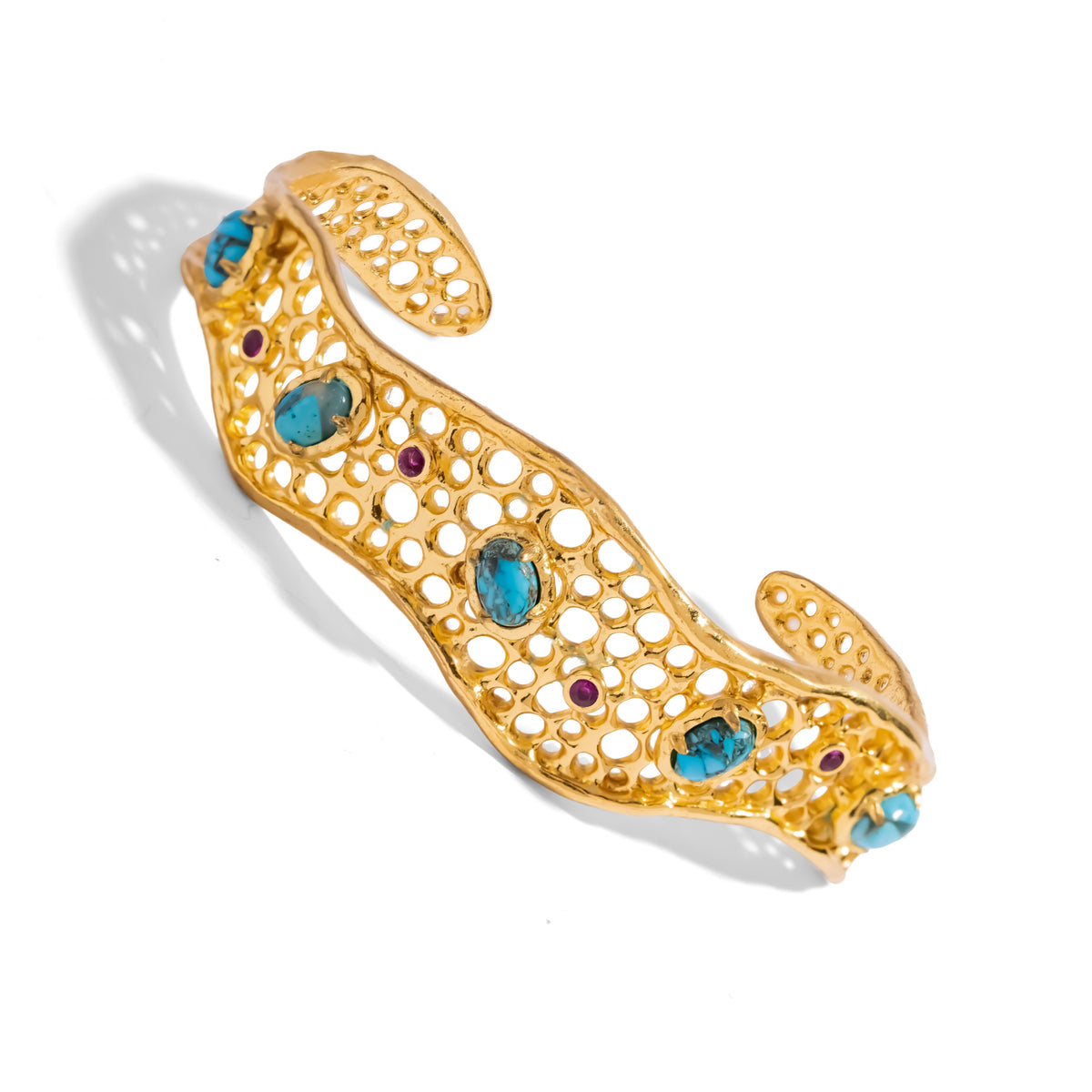 Angled view of the Honeycomb Lace Turquoise & Ruby Gold Cuff Bracelet showing the wavy edges and honeycomb openings
