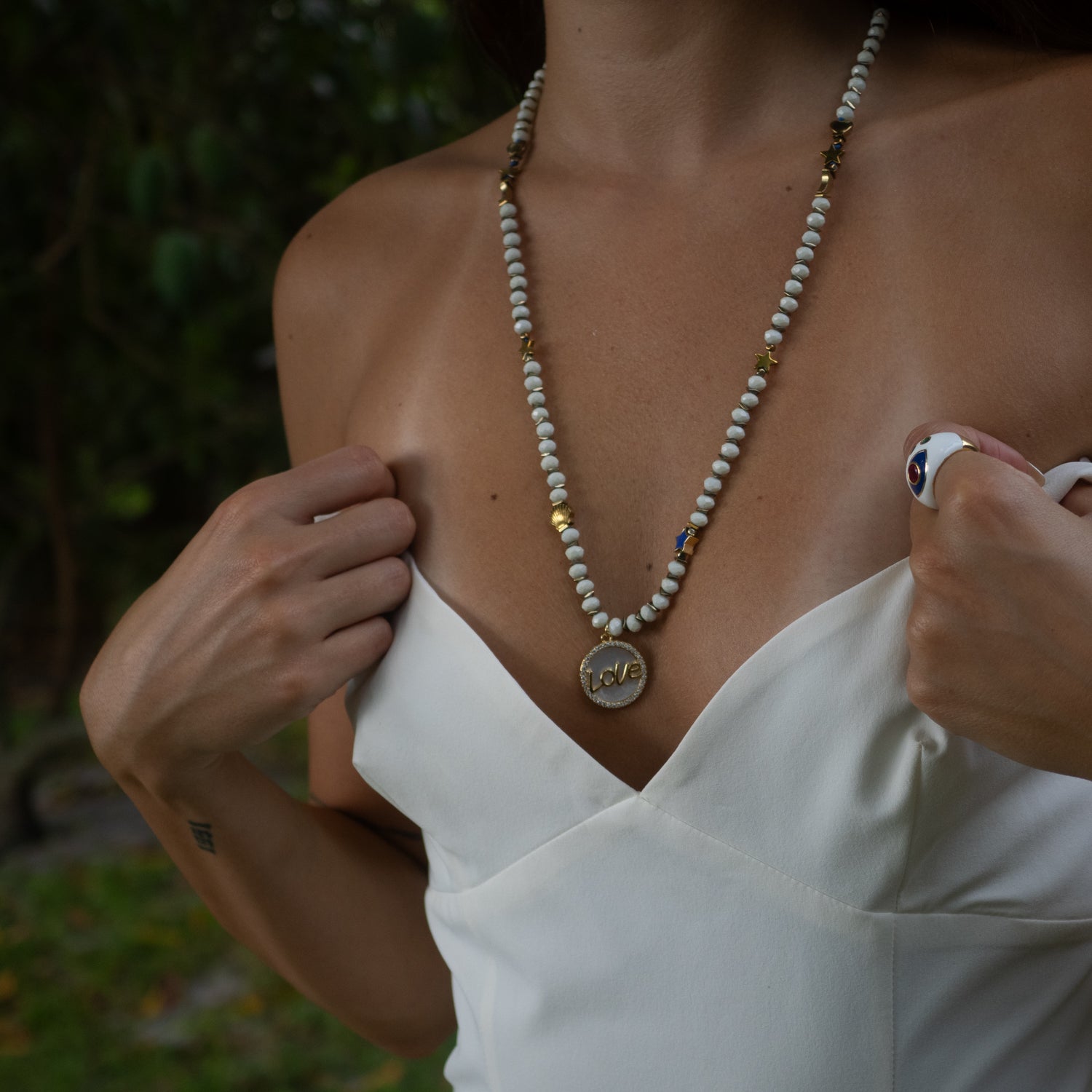 26" crystal beaded necklace with CZ pavé love charm and gold hematite spacers.

