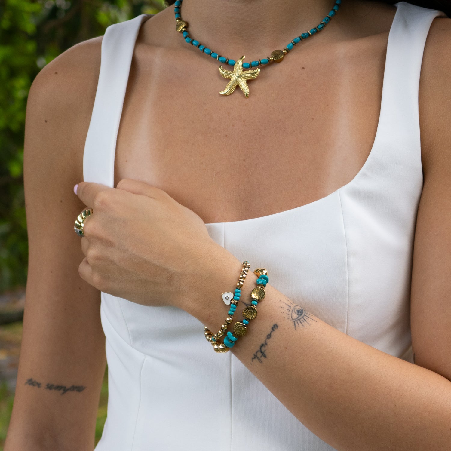 Handmade turquoise and gold beaded bracelet set with white enamel heart charm

