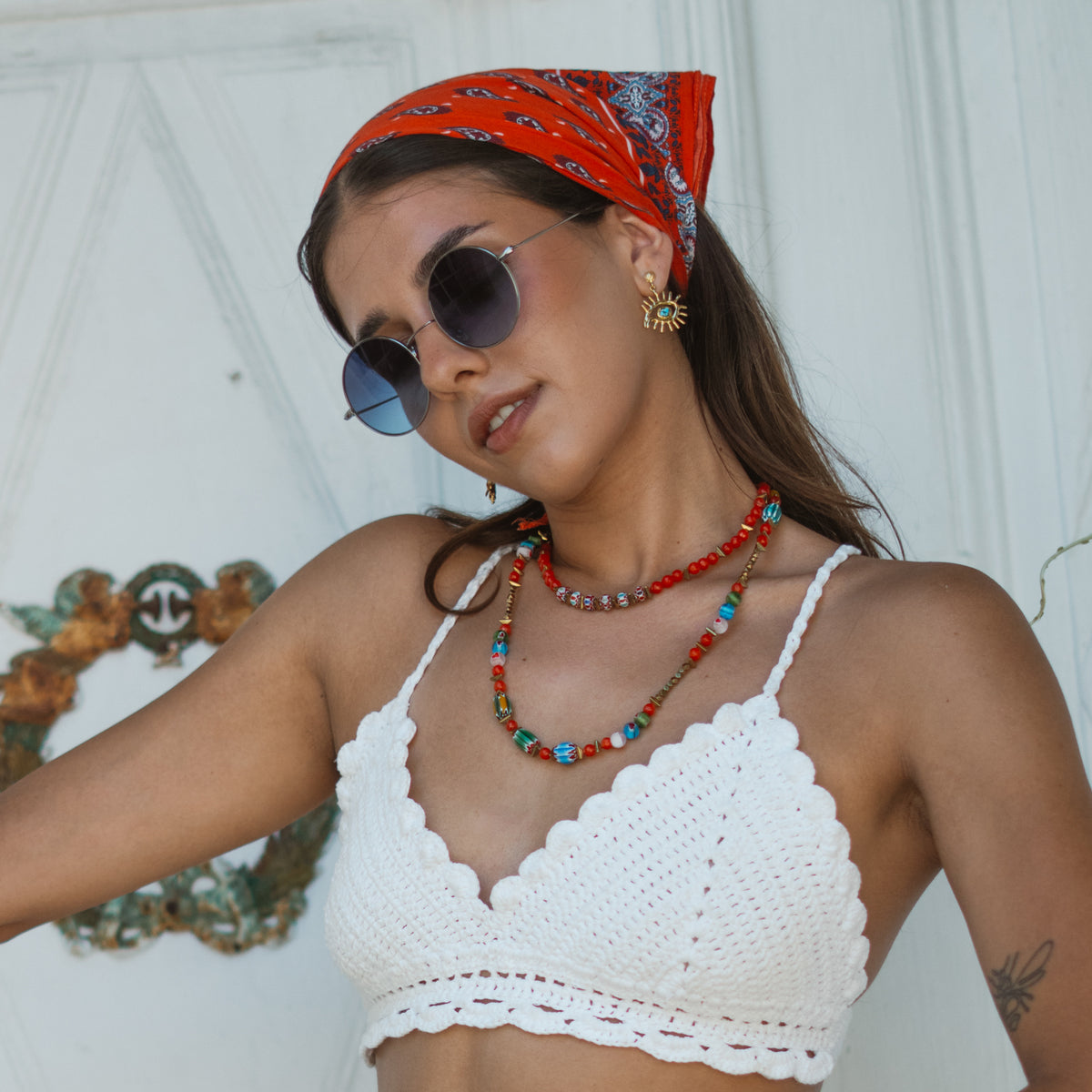 Model in sunglasses and a red headscarf wearing the Kept Safe Evil Eye Turquoise Gold Drop Earrings