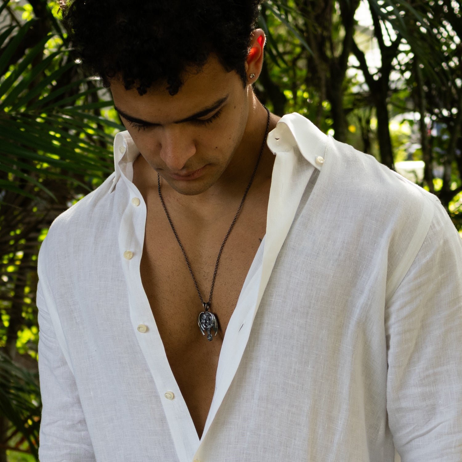 Sterling silver necklace with detailed dragon wrapped around cross pendant, rhodium-plated finish, textured scales, bold masculine style.