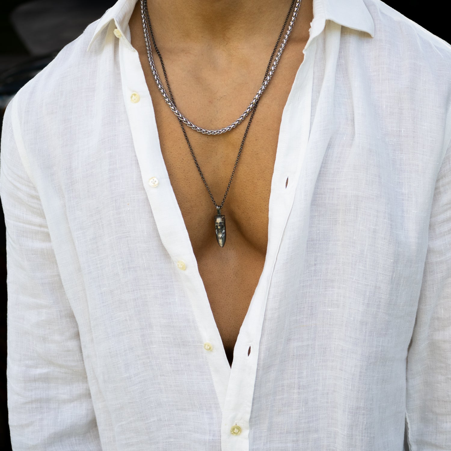 Sterling silver necklace with dark rhodium antique finish, features a skull and fang pendant, 26-inch chain, handcrafted.