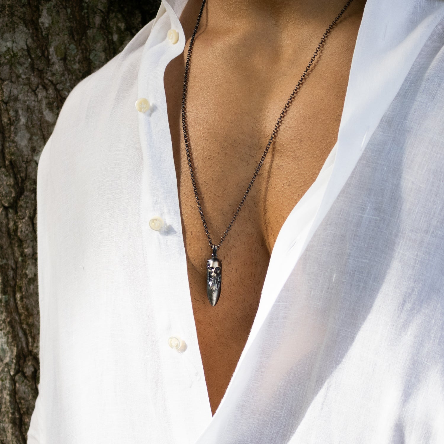 Bold sterling silver necklace with handcrafted skull and fang pendant, dark rhodium finish, 26-inch chain, masculine design.