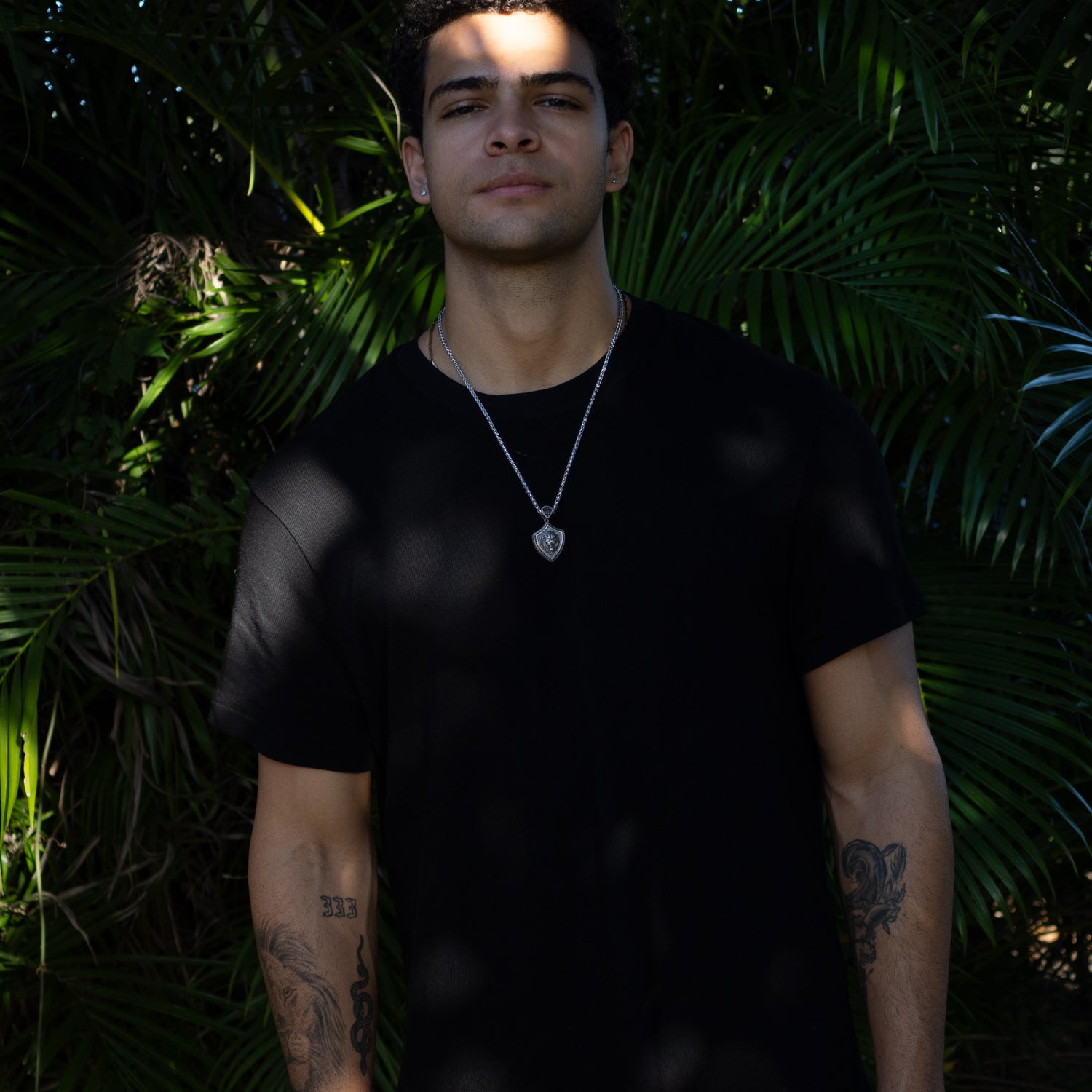 Men’s sterling silver necklace with a shield pendant featuring a 3D lion head design, rhodium finish, and polished silver chain.