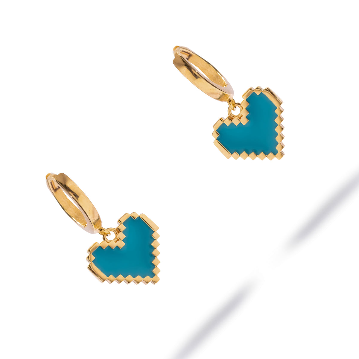 Pair of turquoise enamel heart gold huggie hoop earrings from above, showing the pixel heart shape