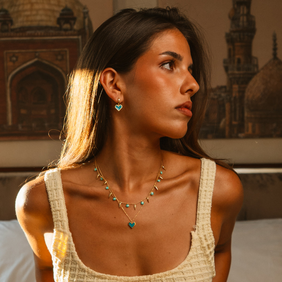 Model in profile wearing the Love in Color turquoise heart hoop earrings and matching heart pendant necklace