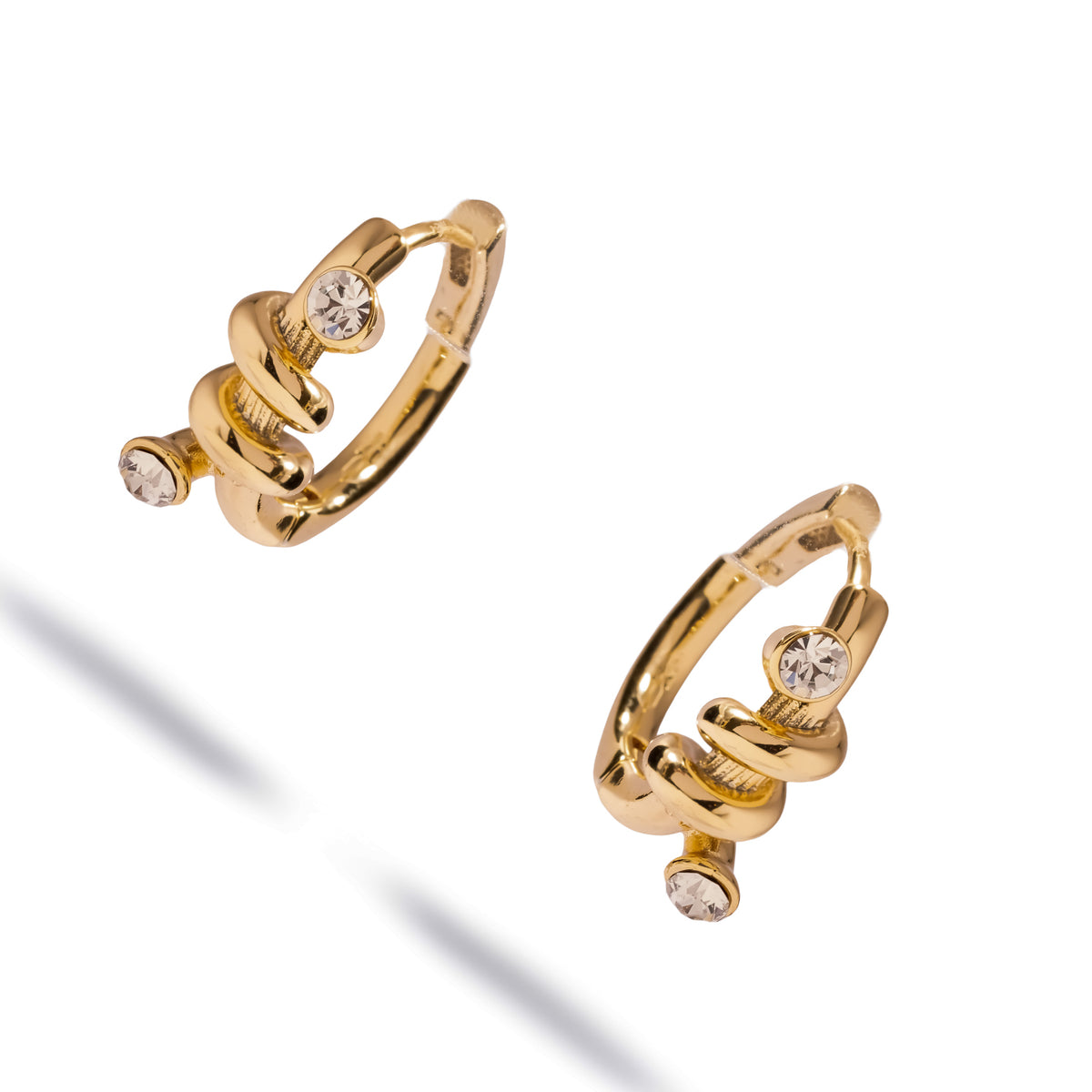 Angled studio view of the love knot huggie hoops showing the hinged closure and the way the knot coils around the band