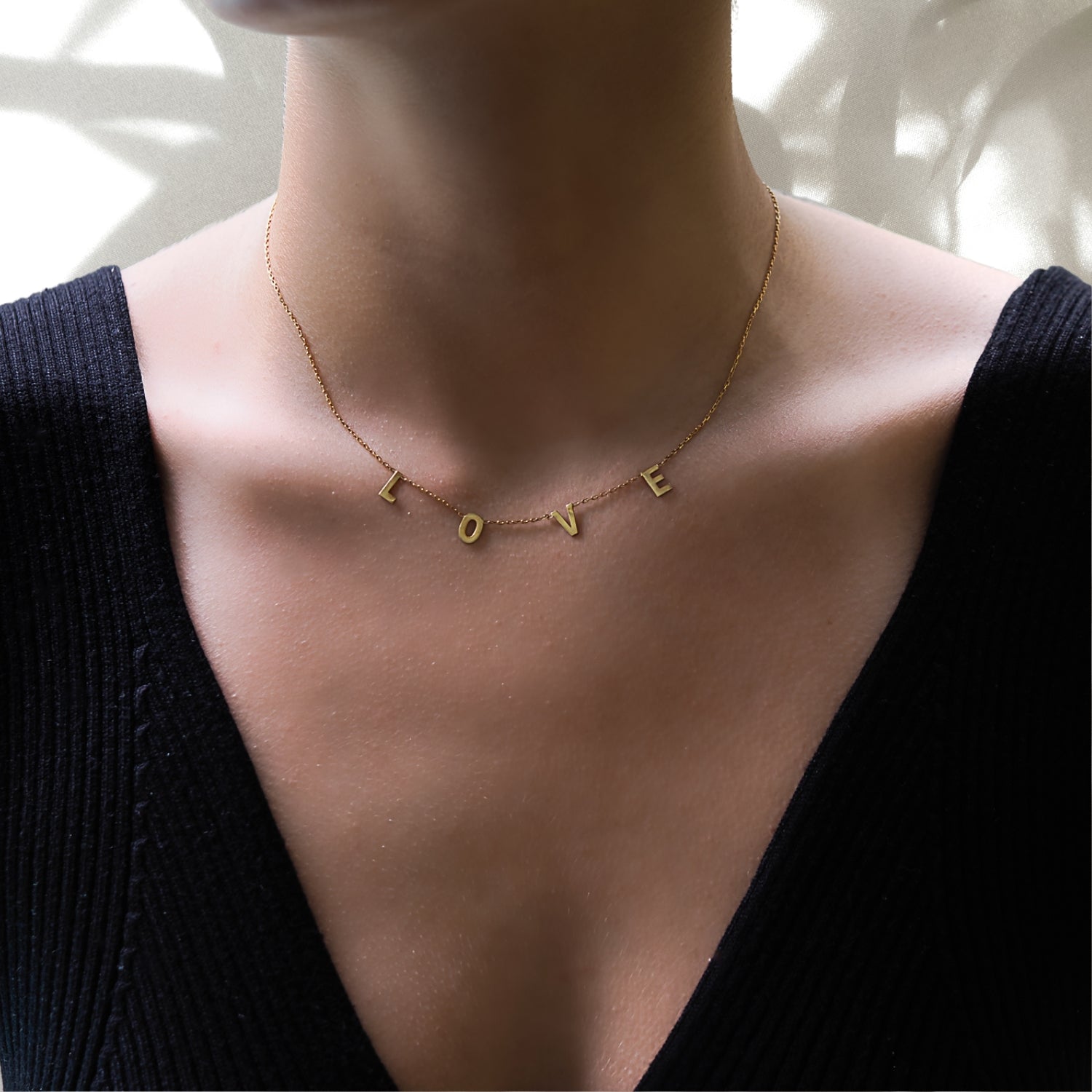 See how the Love Necklace enhances our model's natural beauty, adding a touch of elegance and sophistication to her neckline.