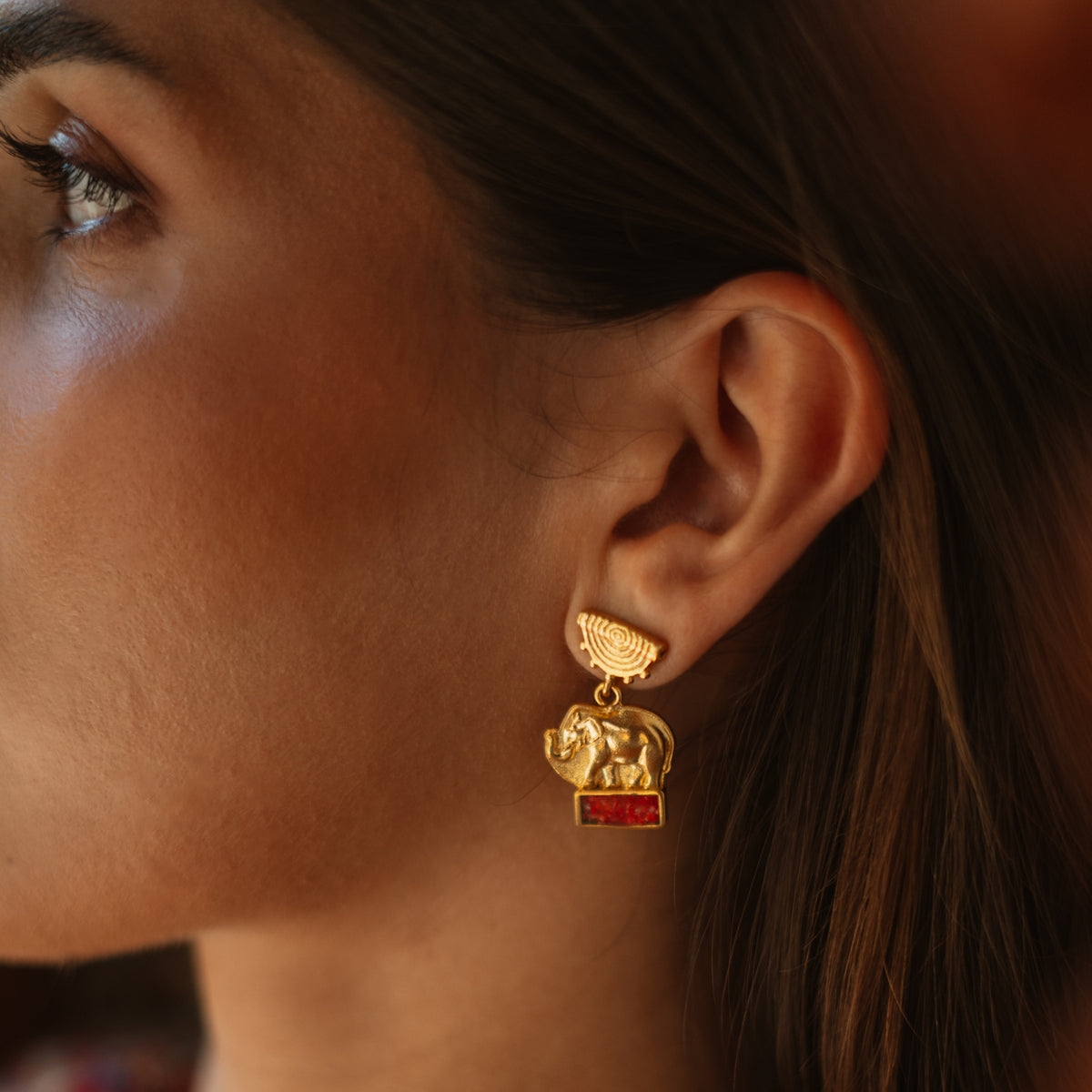 Lucky Elephant Coral Mosaic Gold Drop Earrings worn below the ear, the half sun disc top sitting on the lobe