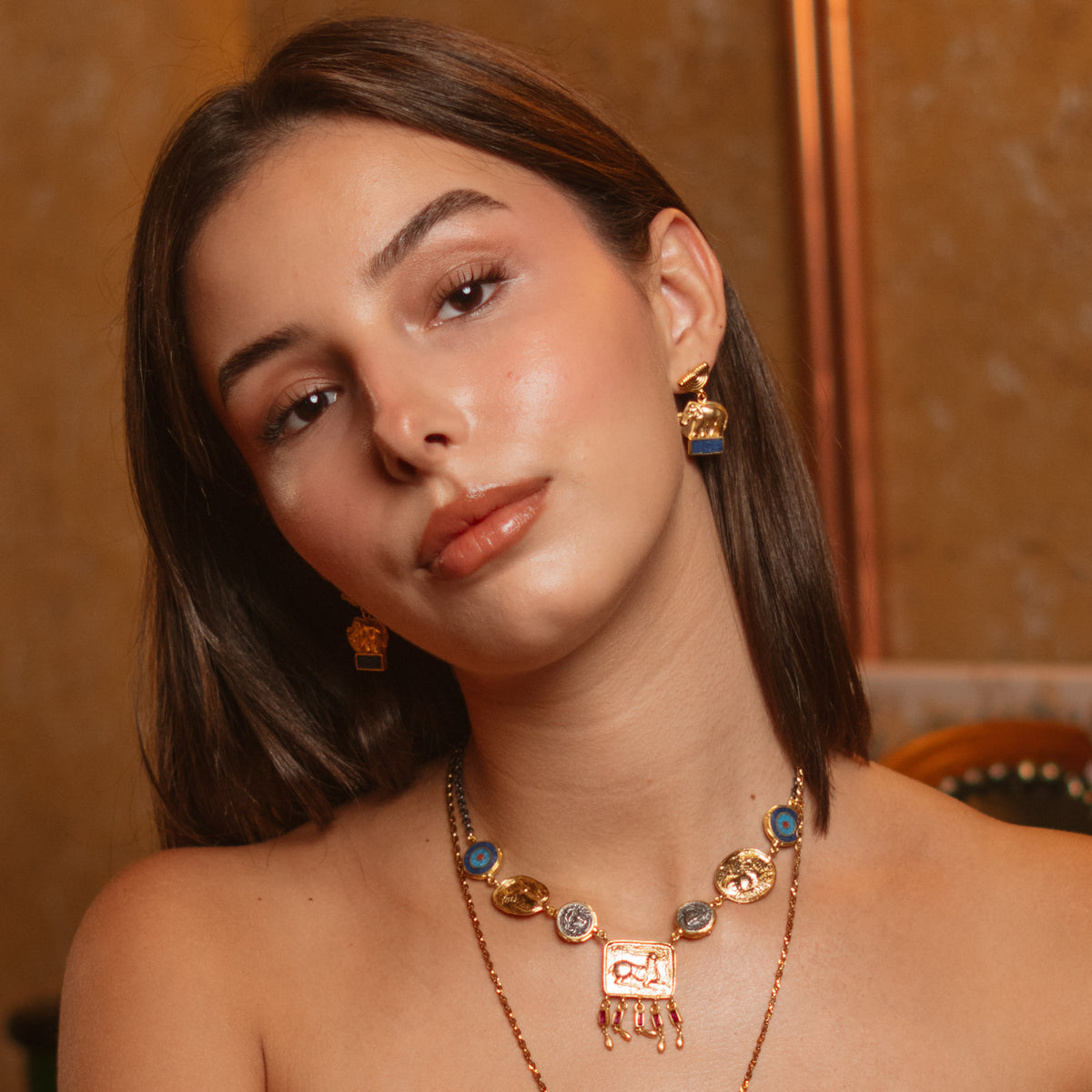 Model wearing the Lucky Elephant Lapis Lazuli Gold Drop Earrings with layered Ebru Jewelry gold and lapis necklaces