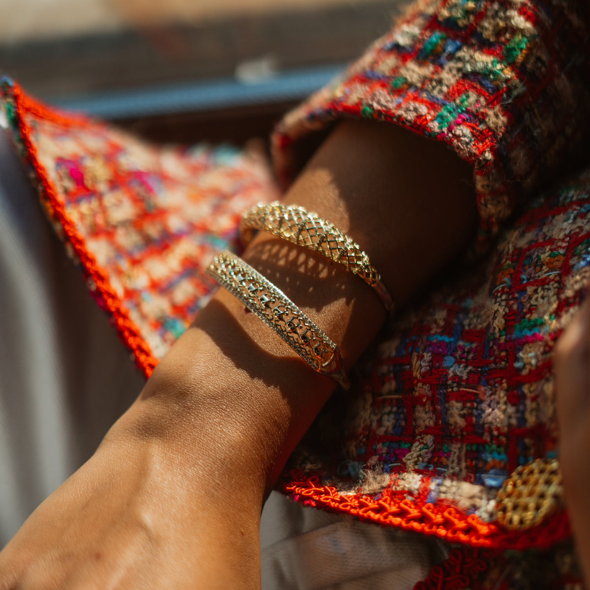 Lucky elephant pave gold bangle stacked with the Diamond Lattice Gold Bangle on a sunlit wrist